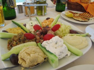 Mixed Greek appetizer platter, with hummus, fava, spicy eggplant, spicy cheese, octopus salad